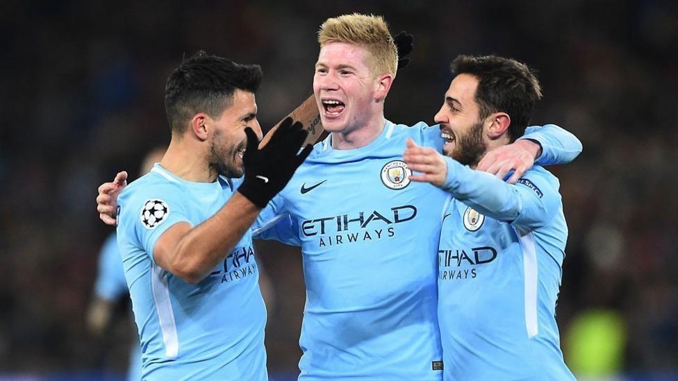 Sergio Aguero, Kevin de Bruyne, and Bernardo Silva celebrate by embracing one another after Manchester City scored a goal in the Champions League